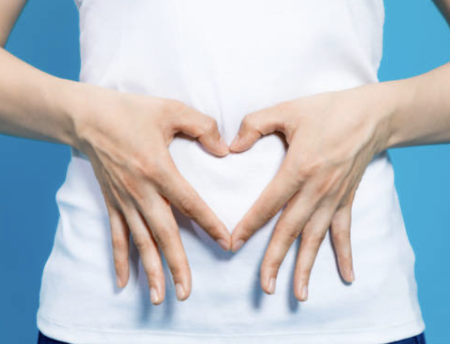 Image depicting a women indicating that she has a healthy gut symbolizing the importance of gut health and nutrition. Text overlay reads 'Unlock the secrets to a healthier gut' with hashtags including